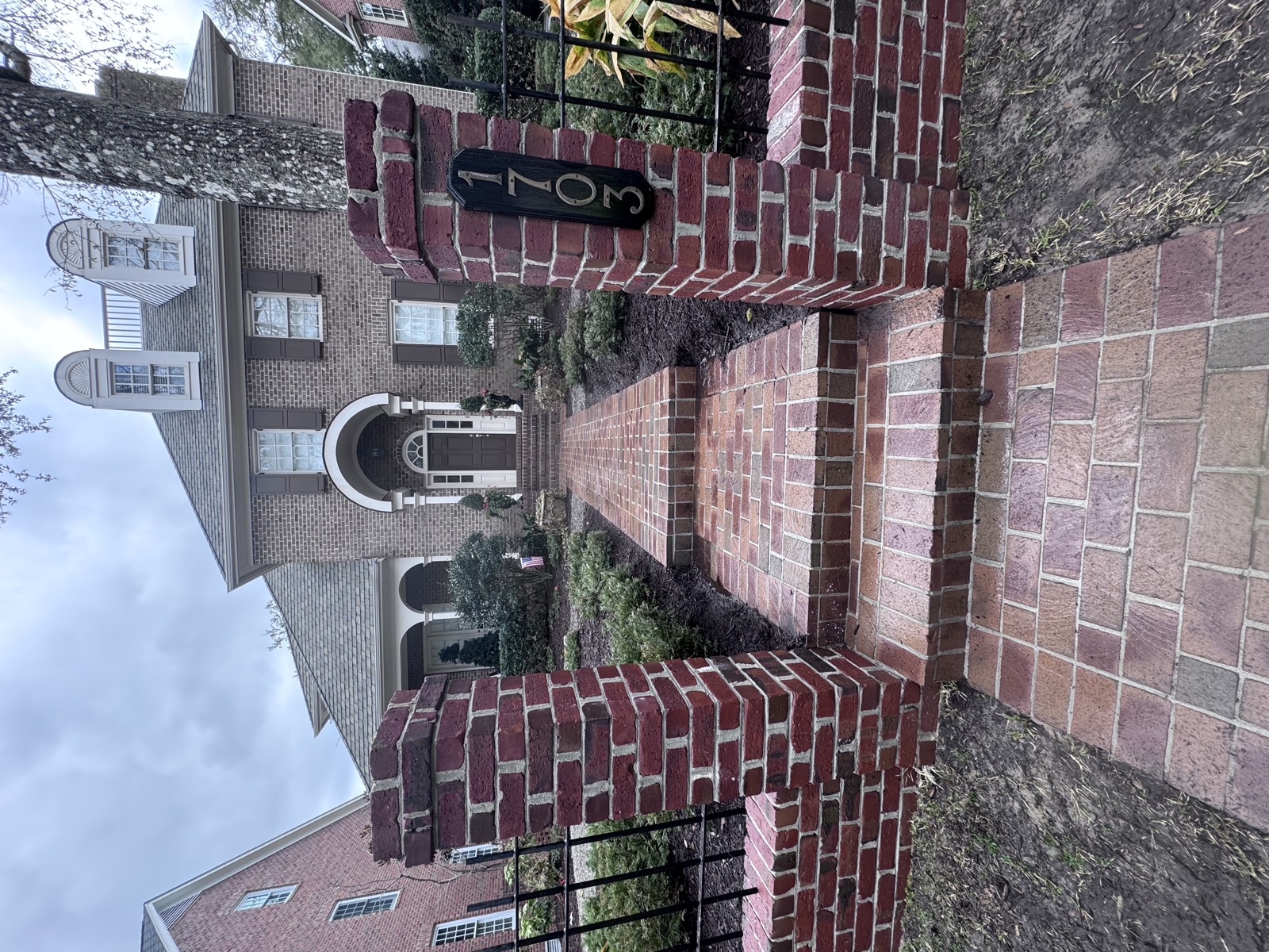 Clean brick walkway and front steps leading to a large brick home