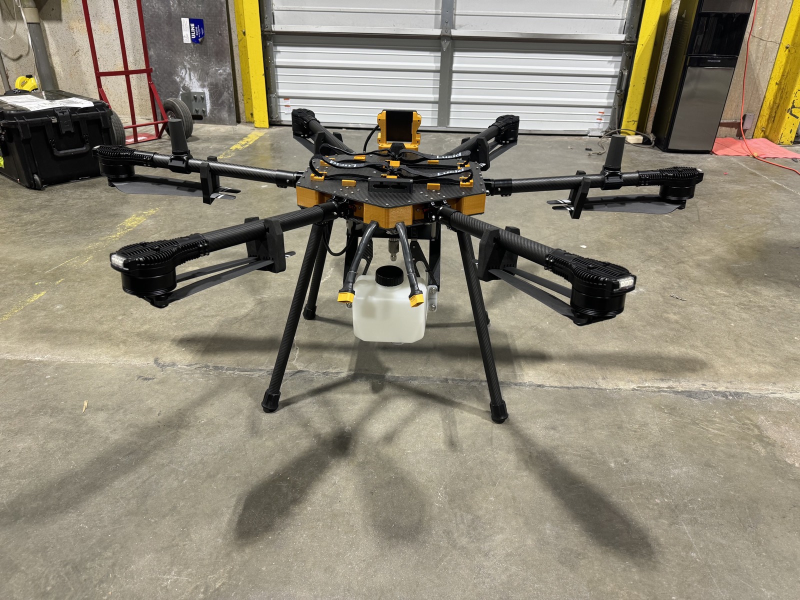 Commercial cleaning drone with spray tank parked in a warehouse before a job