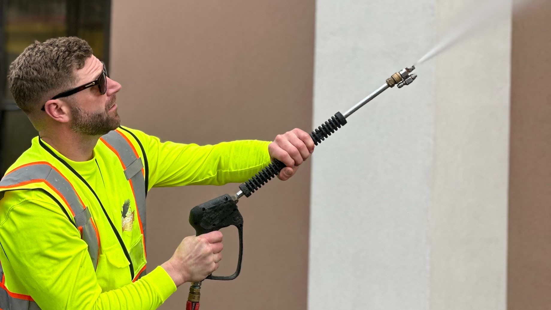Wilmington Pressure Washing soft washing the wall of a building